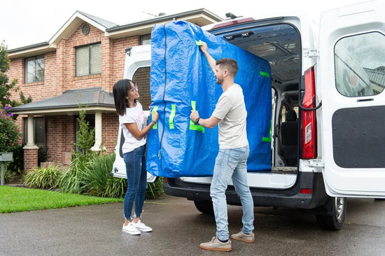 Mattress cover for moving being carried out of the moving truck on moving day after it has been in storage